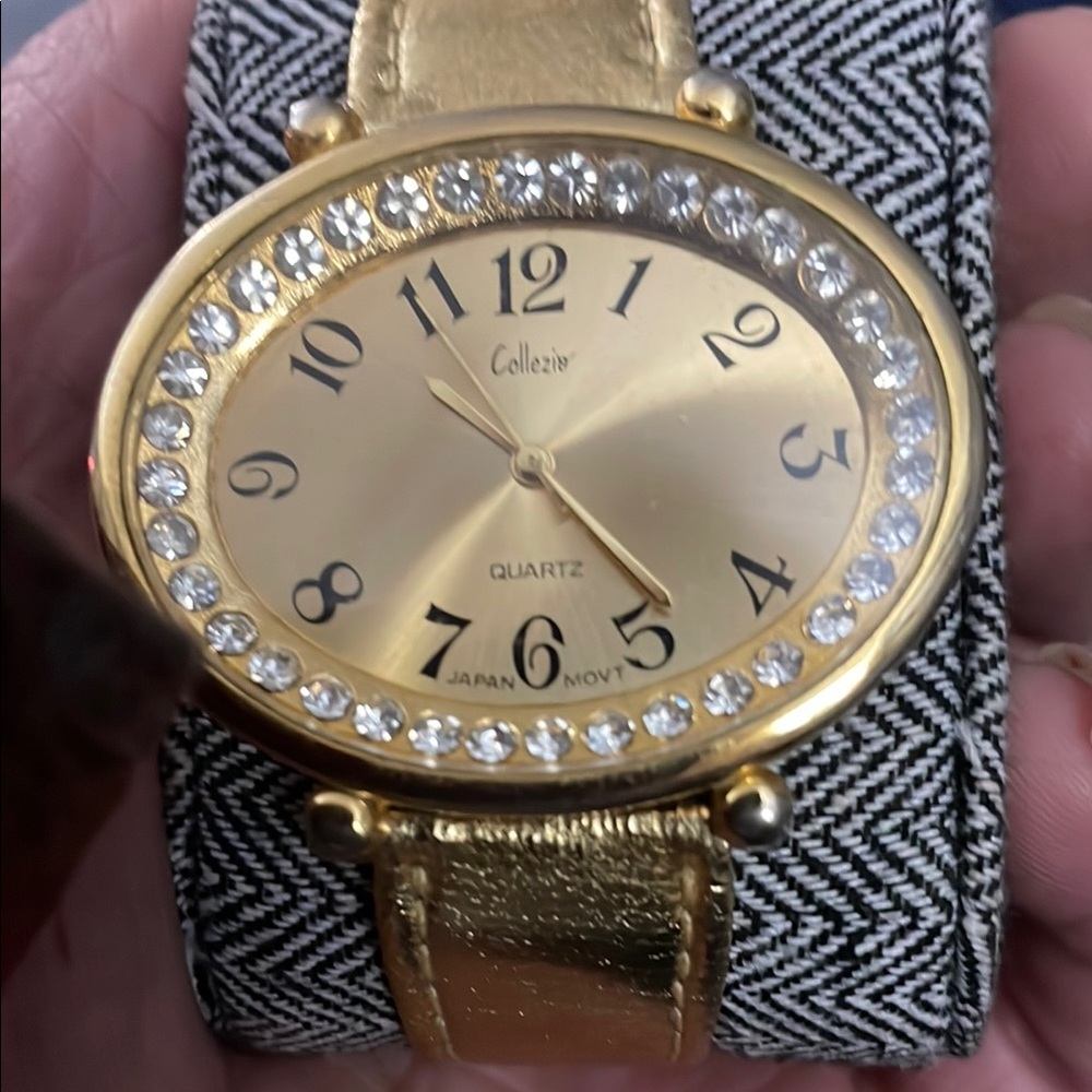 Gold Oval Face Watch with Gemstone Bezel and Metallic Band